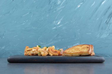 Yağda pişmiş yumurta ve siyah tabakta ekmek dilimleri. Yüksek kalite fotoğraf