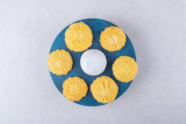 Mini kremalı pasta ve mermer arka planda bir tabakta lezzetli kurabiyeler. Yüksek kalite fotoğraf