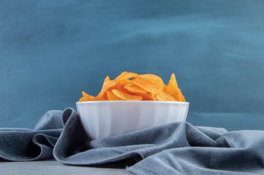 Beyaz kase, arka planda baharatlı patates cipsi dolu. Yüksek kalite fotoğraf