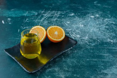 Armut suyu ve dilimlenmiş portakal suyu bir tabakta, mavi arka planda. Yüksek kalite fotoğraf