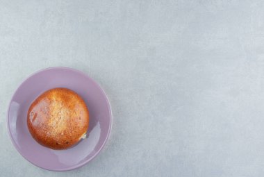 Mor tabakta tatlı bir çörek. Yüksek kalite fotoğraf