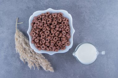 Mısır halkalarının yanında bir bardak süt, mermer arka planda bir kasede. Yüksek kalite fotoğraf