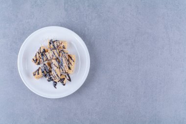 Üzerine çikolata sosu serpiştirilmiş beyaz bir tabak şeker. Yüksek kalite fotoğraf