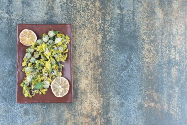 Kahverengi tabakta kurutulmuş kasımpatı ve limon dilimleri. Yüksek kalite fotoğraf