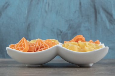 Pişmemiş kalp şeklinde ve beyaz tabakta makarna. Yüksek kalite fotoğraf