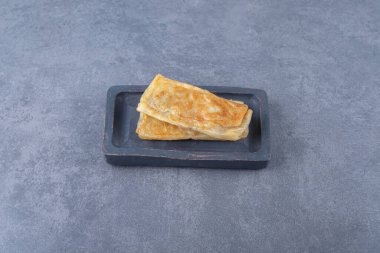 Ahşap tabakta, mermer zemin üzerinde eti olan nefis bir krep. Yüksek kalite fotoğraf