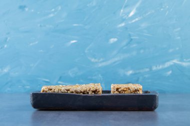 Tahta bir tabakta mermer zemin üzerinde granola çubukları. Yüksek kalite fotoğraf