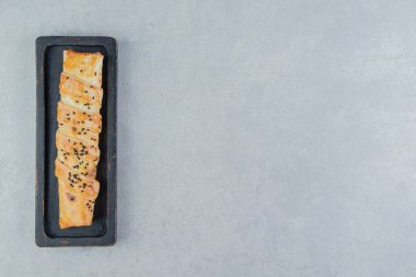 Siyah tabakta susam tohumlu örülmüş çörek. Yüksek kalite fotoğraf