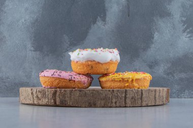 Ahşap parçasına serpiştirilmiş renkli çörekler. Yüksek kalite fotoğraf