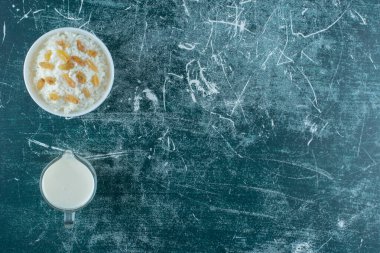 Kuru üzümler bir kase sütlü pudingin yanında, mavi arka planda. Yüksek kalite fotoğraf