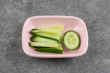 Pembe kasede doğranmış sağlıklı salatalıklar. Yüksek kalite fotoğraf