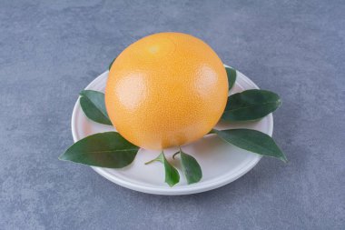 Olgun sulu portakal, plaka üzerinde, mermer zemin üzerinde. Yüksek kalite fotoğraf