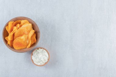 Ahşap bir kase baharatlı cips ve arkaplanda sos. Yüksek kalite fotoğraf