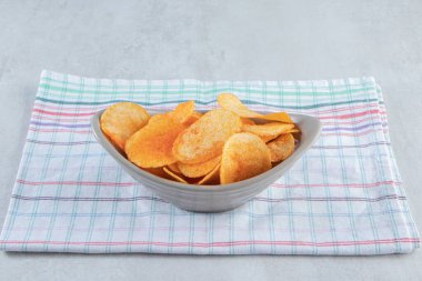 Arka planda baharatlı patates cipsi dolu gri kase. Yüksek kalite fotoğraf