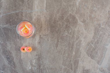 Gri arkaplanda turuncu şekerlerle dolu cam manzarası. Yüksek kalite fotoğraf