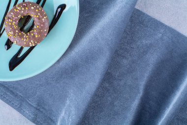 Renkli şekerli çöreklerden oluşan mavi bir tabak. Yüksek kalite fotoğraf