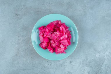 Kırmızı mayalanmış lahana turşusu tabakta, mavi arka planda. Yüksek kalite fotoğraf
