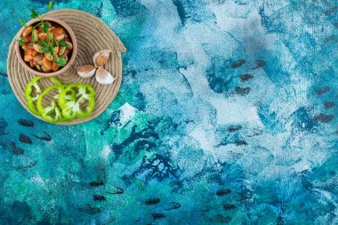 Bir kase fırında fasulye, maydanozlu, sarımsağın yanında bir biber, mavi arka planda. Yüksek kalite fotoğraf