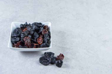 Taş zeminde beyaz bir kase kurutulmuş hurma. Yüksek kalite fotoğraf