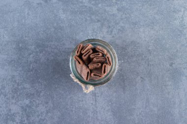 Mermer arka planda, kavanozda lezzetli çikolatalı gofret rulosu. Yüksek kalite fotoğraf