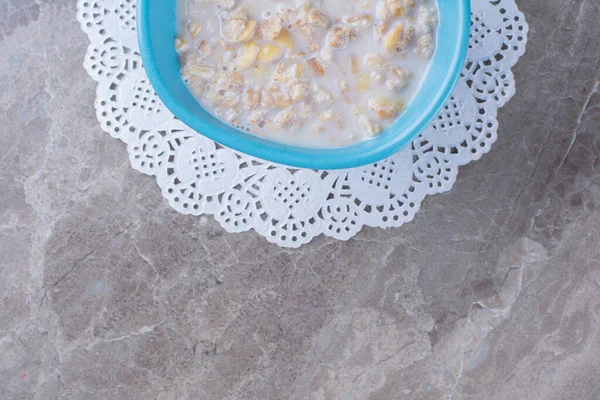 Mavi bir kase sağlıklı mısır gevreği, süt ve tatlı çubuklar. Yüksek kalite fotoğraf