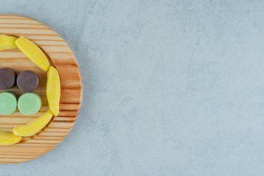 Muz şekilli, çiğneme şekeri ve marmelatla dolu tahta bir tahta. Yüksek kalite fotoğraf