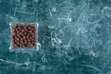 Mavi arka planda cam bir kasede tatlı mısır topları. Yüksek kalite fotoğraf