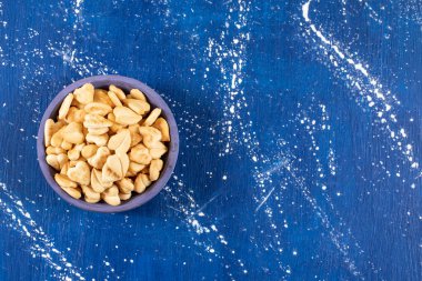 Mavi kaseye konmuş tuzlu kalp şeklinde kraker yığını. Yüksek kalite fotoğraf