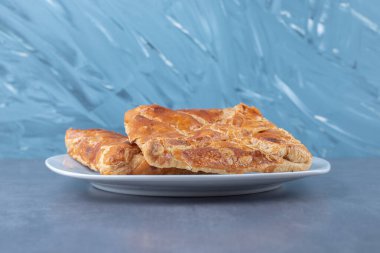 Khachapuri mermer zemin üzerinde bir tabağa yerleştirilmiş. Yüksek kalite fotoğraf