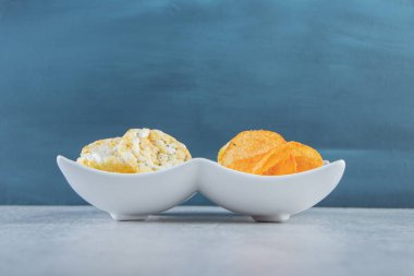 Beyaz kaselerde gevrek kepekli pirinç kekleri ve baharatlı cipsler. Yüksek kalite fotoğraf