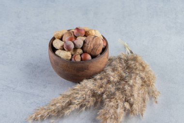 Taş zeminde çeşitli kabuklu cevizlerle dolu ahşap bir kase. Yüksek kalite fotoğraf