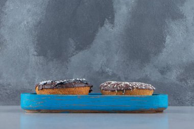 Taştan arka planda mavi bir tabak çikolatalı çörek. Yüksek kalite fotoğraf