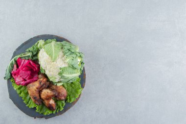 Kızarmış tavuk kanadı ve odun parçasında karnabahar. Yüksek kalite fotoğraf