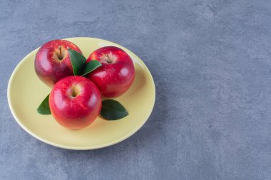 Tatlı elmalar ve yaprak tabakta, mermer arka planda. Yüksek kalite fotoğraf