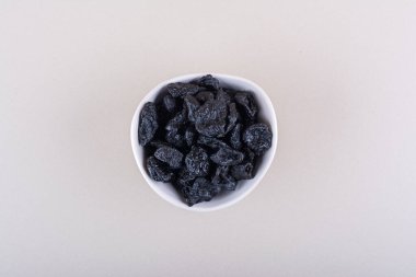 Beyaz arka planda beyaz bir kase kurutulmuş erik meyvesi. Yüksek kalite fotoğraf