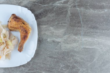 Izgara tavuk budu ve beyaz tabakta doğranmış lahana manzarası. Yüksek kalite fotoğraf