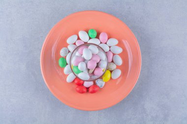 Gri arka planda bir bardak dolusu renkli fasulye şekeri. Yüksek kalite fotoğraf.