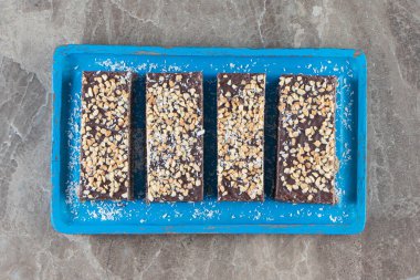 Tahta tabakta fındıklı dilimlenmiş çikolata, mermer arka planda. Yüksek kalite fotoğraf