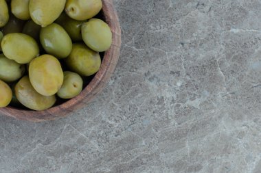 Konserve yeşil zeytinin yakın plan fotoğrafını çek. Tahta kasede yeşil zeytin yığını. Yüksek kalite fotoğraf