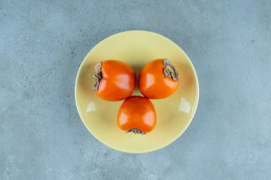 Mermer zemin üzerinde, bir tabakta olgun hurma. Yüksek kalite fotoğraf