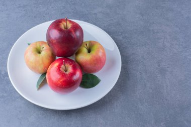 Arkaplanda yapraklar olan lezzetli bir elma. Yüksek kalite fotoğraf