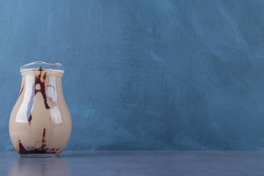 Mermer zemin üzerinde bir sürahi kremalı latte. Yüksek kalite fotoğraf