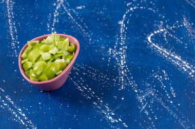 Mermer arka planda pembe bir kase olgun yeşil dolma biber. Yüksek kalite fotoğraf