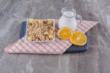 Sağlıklı mısır gevreği ve tahta bir tahtanın üzerinde portakal meyvesi dilimleri olan bir kavanoz süt. Yüksek kalite fotoğraf