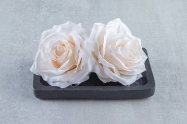 Beyaz arka planda, tahta bir tabakta çiçekler. Yüksek kalite fotoğraf