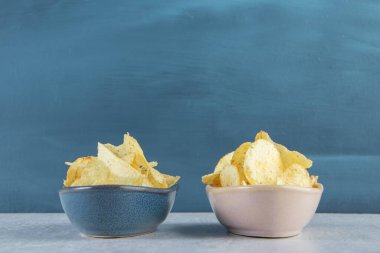 Arka planda iki kase tuzlanmış çıtır cips. Yüksek kalite fotoğraf