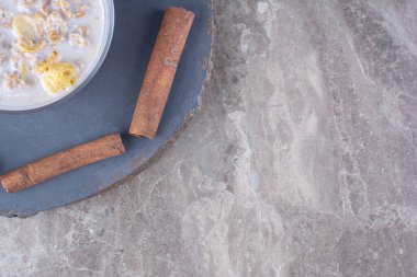 Süt ve tarçın çubuklu sağlıklı mısır gevreği kasesi. Yüksek kalite fotoğraf