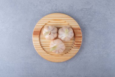 Ahşap tabakta tam sarımsak, mermer arka planda. Yüksek kalite fotoğraf