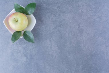 Arkaplanda yaprakları olan tek bir elma. Yüksek kalite fotoğraf