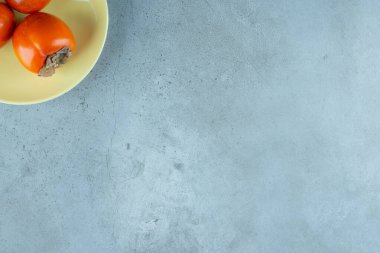 Mermer zemin üzerinde, bir tabakta olgun hurma. Yüksek kalite fotoğraf